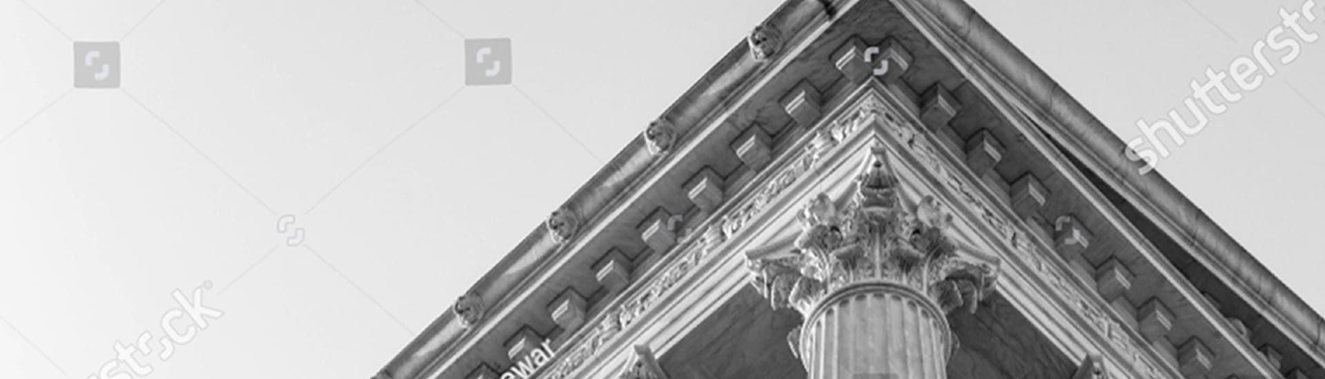 Black and white close-up of classical courthouse columns and pediment